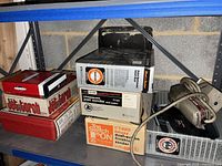 Shelf view showing boxed Jet Torch kits, boxed sanders and loose pad sander