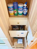 Cabinet with wipes, cleanser, cleaner, tumbler, drawers containing toiletries and towels