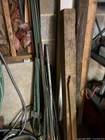 Wood boards, garden stakes, metal rods leaning against wall