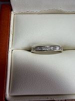Front view of 14kt gold diamond band ring in box