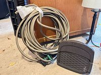 Coiled gray hose with connector and Suncast storage box front