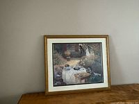 Framed Monet print upright on wooden surface