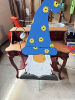 Full view of painted wooden gnome yard stake with accessories