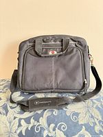 Front view showing Swissalps logo, exterior pocket, shoulder strap and handles