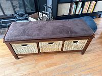 front view of wood bench with three baskets and cushion