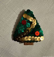 Front view of green sequin Christmas tree brooch