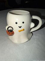 Front of ghost mug showing facial features, bow tie and pumpkin bucket