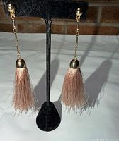 Front view of tassel earrings on stand