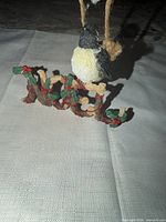 Front view of ornament showing bird and NOEL twig letters with holly detail