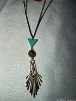 Full view of the necklace laid flat showing chain and pendant components