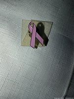 Front view of pink ribbon pin on card