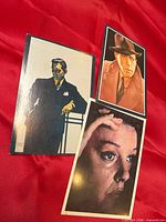 All three portrait postcards laid out on red fabric