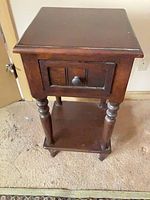 Front view of square wood side table with drawer and shelf