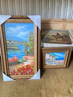 Overview of three paintings: two framed, one unframed