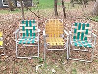 Three aluminum lawn chairs with green, yellow and green webbing