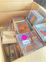 Large cardboard box filled with numerous CD jewel cases