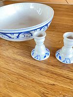 Bowl with two candlesticks on wood surface