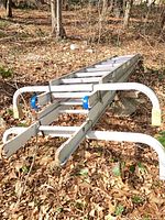 Full view of collapsed ladder with stabilizer arms and padlocked chain