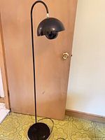 Full view of floor lamp showing arched stem, dome shade, base