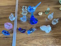 Group view of all glass animal and fruit figurines on wooden surface