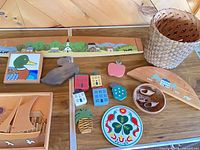 Overview of assorted wooden items, basket and ceramic trivet laid out