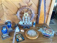 Overall lot with ship wheel, model ship, porthole clock, ship in bottle, bookends, bell, figurine, lighthouse slab, booklet and shell