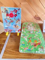 Front view of both tabletop games showing graphics and play fields