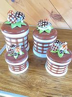 Set of four brown-white checkered ceramic mushroom-top canisters
