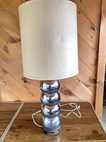 Full view of lamp with shade showing stacked chrome spheres and cord