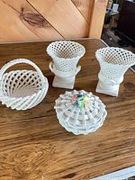 overview of all four white reticulated ceramic pieces on table