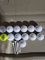 Full set of 13 golf balls arranged with white tees