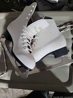 Side view of both skates showing uppers, laces, blades and heel