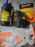 Group shot showing DeWalt laser, chalk bottle, CutMaster gloves, Grabber warmers