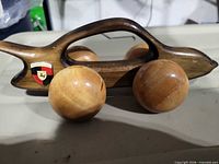 Side view of wooden Porsche model showing overall shape, handle cutout, wheels, and crest