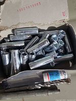 Box of zinc drop-in anchors with drill bit visible