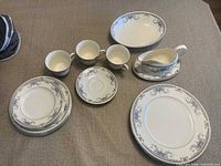 Full set of plates, cups, saucer, serving pieces on table