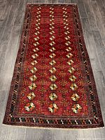 Full view of red Turkman runner rug showing entire design and fringe