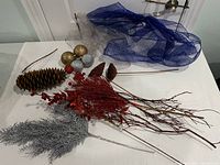 lot overview on tabletop with mesh, ornaments, pine cone, picks