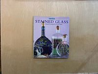 Front cover of the hardcover book showing title and images of stained glass projects