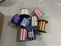 Top view of eight assorted curling ribbon spools showing colors and partial usage
