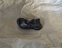 Top view of otter with baby figurine on packing paper