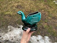 Left profile of green drip-glaze swan planter held in hand