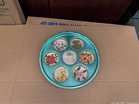 top view of tray with seven illustrated coasters in place