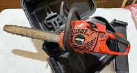 Echo CS-400 chainsaw resting inside open hard plastic carry case