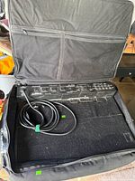 Open case with pedalboard and cable visible