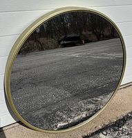 Front view of round mirror leaning against wall