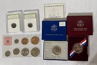 Group shot showing all boxed coins, New Zealand set, two loose coins and certificate