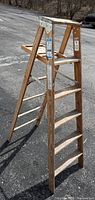 Full view of wooden 6-step ladder opened on pavement