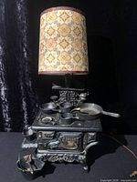 front view showing stove, cookware, and lampshade