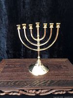 Frontal view of gold plated menorah on wooden surface